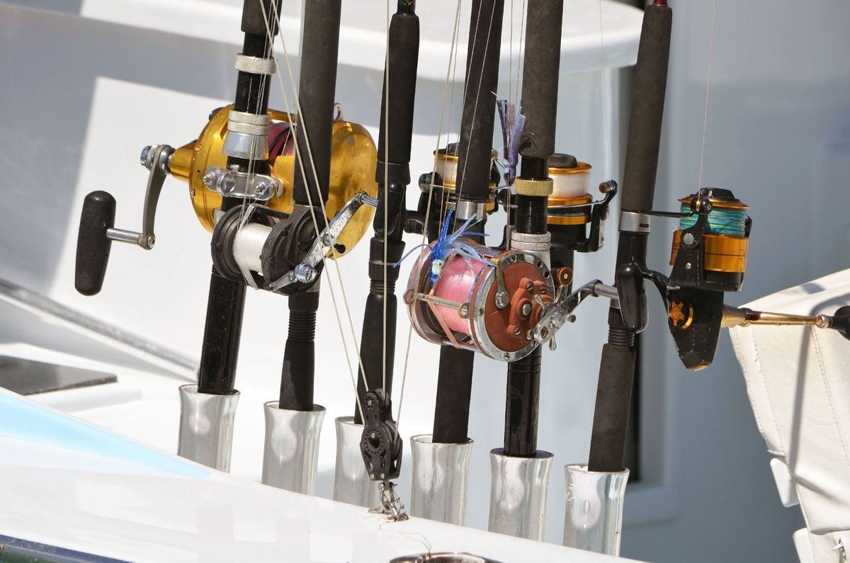 An assortment of deep sea fishing rods and reels on a charters sport fishing boat.